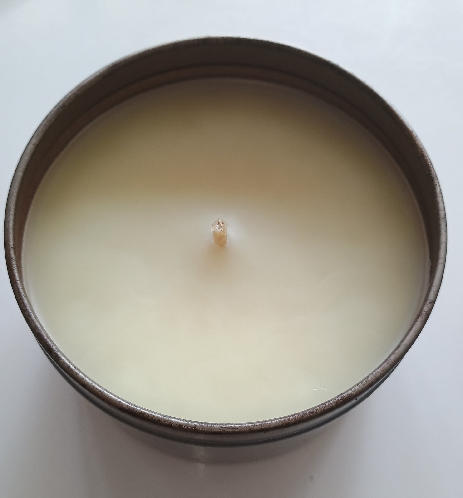 Candle in a metal container on a white background